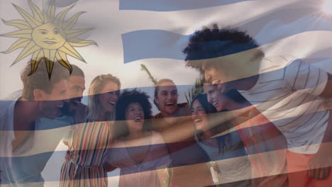 Animation-of-uruguay-flag-waving-over-diverse-friends-forming-human-chain-at-beach