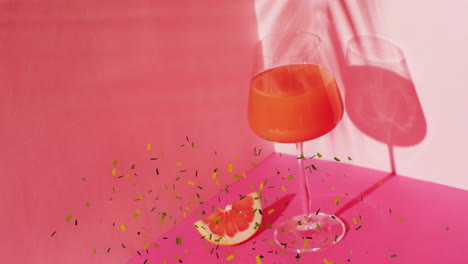 Animation-of-confetti-falling-and-cocktails-on-pink-background