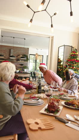 Video-Vertical-De-Amigos-Mayores-Felices-Y-Diversos-En-La-Mesa-De-La-Cena-De-Navidad,-Espacio-Para-Copiar,-Cámara-Lenta