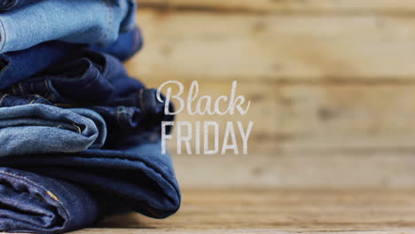 Animation-of-black-friday-text-over-denim-trousers-on-wooden-background