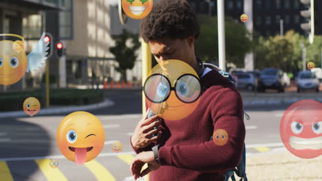 Animation-of-multiple-emojis-over-biracial-man-walking-and-scrolling-on-smartwatch-on-street