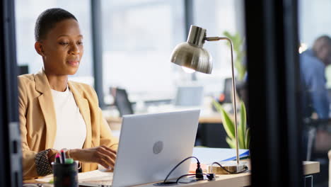 Portrait-of-african-american-businesswoman-using-laptop-in-office,-slow-motion,-copy-space