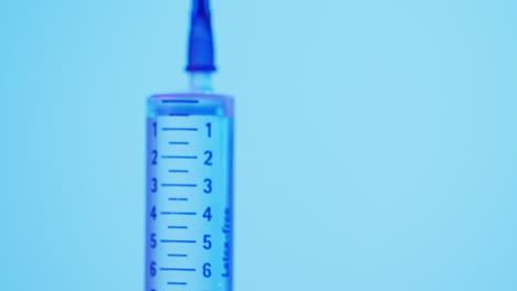 Video-of-laboratory-syringe-with-copy-space-on-blue-background