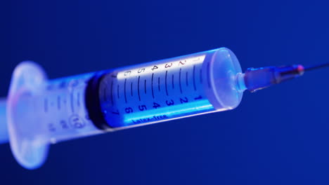 Video-of-laboratory-syringe-with-copy-space-on-blue-background