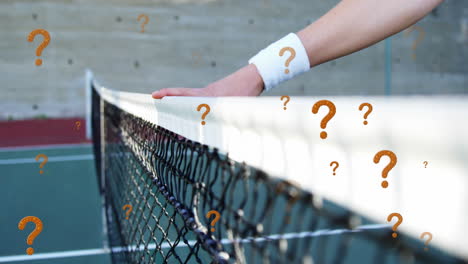 Animation-of-question-mark-symbol-over-cropped-hand-of-caucasian-tennis-player-on-net