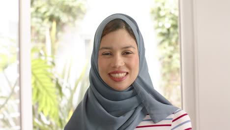 Porträt-Einer-Lächelnden-Biracial-Frau-Im-Hijab-Zu-Hause-Mit-Kopierraum,-Zeitlupe