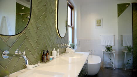 Schöne-Spiegel,-Wasserhähne,-Waschbecken-Und-Grüne-Wände-In-Sonnigem-Badezimmer