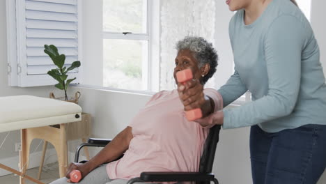 Caucasian-nurse-with-senior-woman-in-wheelchair-exercising-with-copy-space,-slow-motion