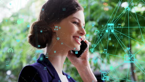 Animation-of-connected-icons-forming-globe-over-smiling-caucasian-woman-talking-on-cellphone