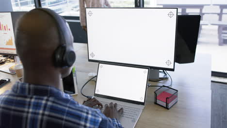 Afroamerikanischer-Geschäftsmann-Verwendet-Computer-Und-Tablet-Mit-Leerem-Bildschirm,-Zeitlupe,-Kopierraum