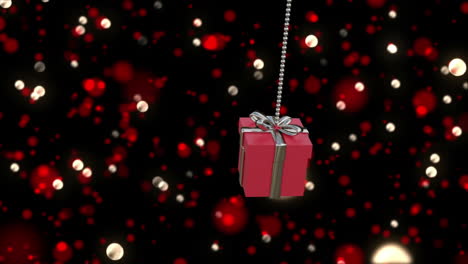 Animation-of-christmas-red-gift-bauble-over-spots-of-lights-background