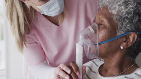 Kaukasische-Krankenschwester-Mit-Gesichtsmaske,-ältere-Afroamerikanerin-Mit-Sauerstoffmaske,-Zeitlupe
