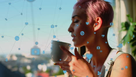 Animation-of-icons-connected-with-lines,-biracial-woman-enjoying-coffee-while-looking-through-window