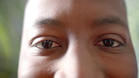Porträt,-Nahaufnahme-Der-Augen-Eines-Glücklichen-Afroamerikanischen-Mannes,-Der-In-Der-Sonne-Lächelt,-Zeitlupe