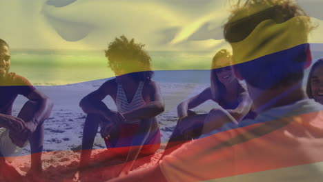 Animation-of-waving-flag-of-colombia-over-diverse-friends-spending-quality-time-at-beach