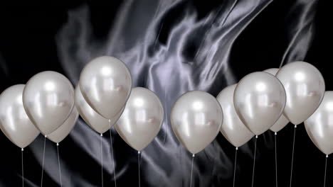 Animation-of-silver-balloons-over-black-background