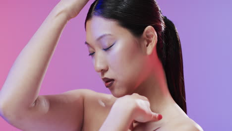 Asian-woman-with-black-hair-and-make-up-touching-her-face,-copy-space,-slow-motion