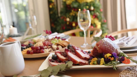Essen-Auf-Dem-Esstisch-Für-Die-Weihnachtsfeier-Mit-Baum-Im-Hintergrund,-Zeitlupe