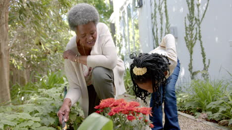 Happy-african-american-grandmother,-granddaughter-and-grandson-gardening-together,-slow-motion