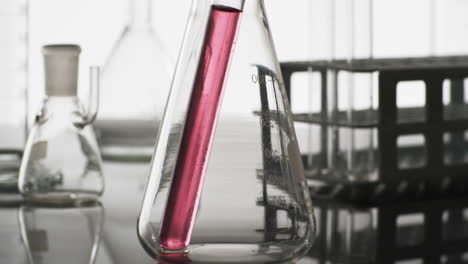 Video-Eines-Laborreagenzglases-Aus-Glas-Mit-Rosa-Flüssigkeit-Im-Becher-Mit-Kopierraum-Auf-Weißem-Hintergrund