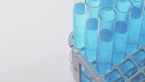 Video-of-glass-laboratory-test-tubes-with-blue-liquid-with-copy-space-on-white-background