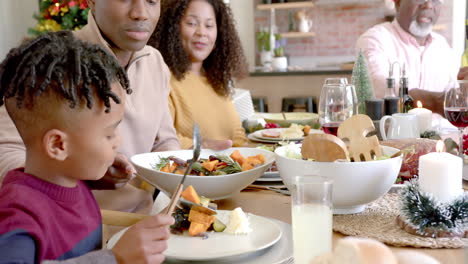 Glücklicher-Afroamerikanischer-Vater-Serviert-Sohn-Essen-Am-Weihnachtstisch-Der-Familie
