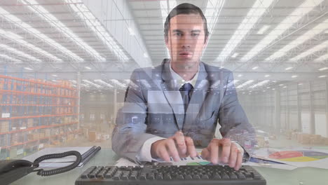 Animation-of-aerial-view-of-warehouse-over-confused-caucasian-man-typing-on-keyboard-at-office