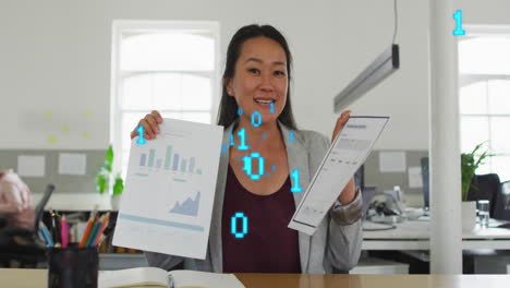Animation-of-binary-codes-over-asian-woman-discussing-reports-during-video-call-on-laptop
