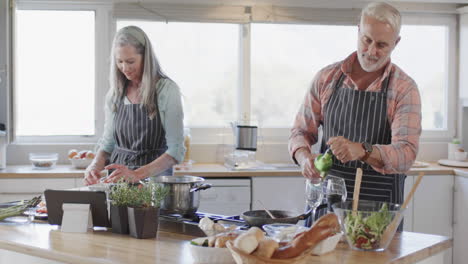 Middle-aged-caucasian-couple-preparing-meal,-cooking-together-in-kitchen-at-home,-slow-motion