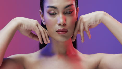 Biracial-woman-with-black-hair-and-make-up-touching-her-face,-copy-space,-slow-motion