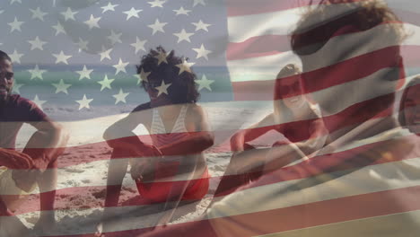Animation-of-national-flag-of-america-over-diverse-friends-sitting-and-talking-on-beach