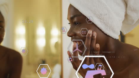 Animation-of-multiple-icons-over-african-american-applying-cream-on-face-after-taking-bath