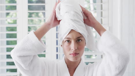 Biracial-woman-wearing-towel-on-head-in-bathroom,-slow-motion
