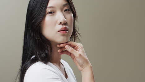 Asian-woman-with-black-hair-and-make-up-touching-face,-copy-space,-slow-motion