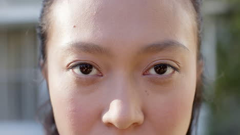 Portrait-close-up-of-opening-eyes-of-happy-biracial-woman-outdoors,-slow-motion
