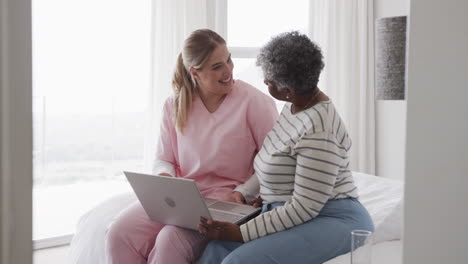 Kaukasische-Krankenschwester-Und-ältere-Afroamerikanerin-Mit-Laptop,-Kopierraum,-Zeitlupe