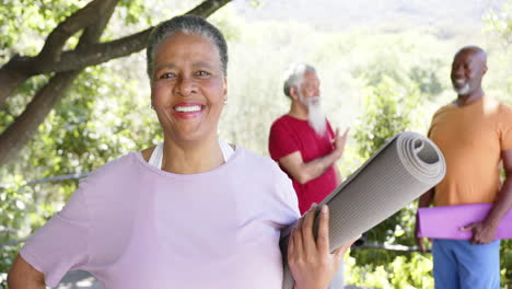 Portrait-of-happy-senior-african-american-woman-with-yoga-friends-in-sunny-nature,-slow-motion
