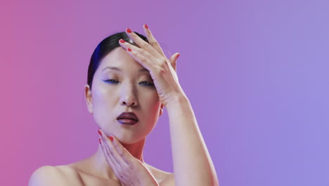 Asian-woman-with-black-hair-and-make-up-looking-at-camera,-copy-space,-slow-motion