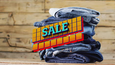 Animation-of-sale-text-over-denim-trousers-on-wooden-background