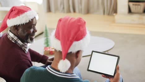 Happy-african-american-father-and-son-having-christmas-tablet-video-call,-copy-space,-slow-motion