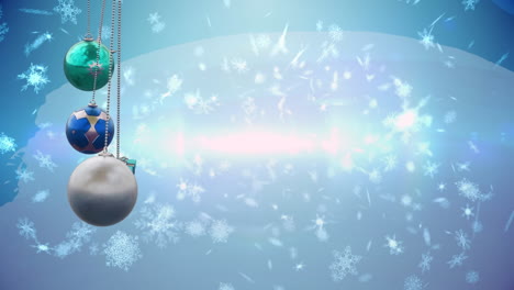 Animation-of-christmas-baubles-over-snow-falling-on-blue-background