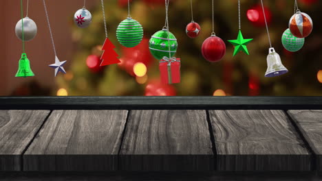 Animation-of-christmas-baubles-over-christmas-tree-and-wooden-background