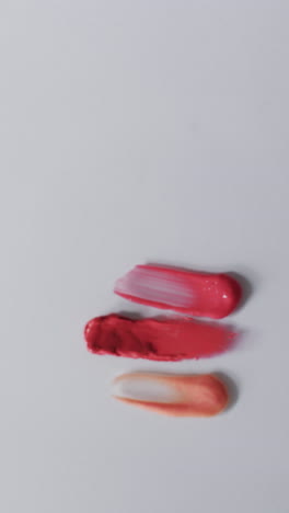 Vertical-video-of-lipstick-smudges-with-copy-space-on-white-background