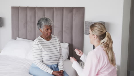 Kaukasische-Krankenschwester-Im-Gespräch-Mit-Einer-älteren-Afroamerikanerin,-Kopierraum,-Zeitlupe