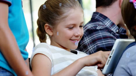Animation-of-falling-numbers-over-close-up-of-smiling-caucasian-girl-using-digital-tablet