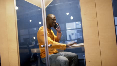 Afroamerikanischer-Geschäftsmann-Nutzt-Smartphone-Und-Computer-Im-Büro,-Zeitlupe,-Kopierraum