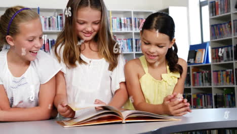 Animation-of-multiple-numbers-and-symbols-over-caucasian-girls-reading-book-in-library-room