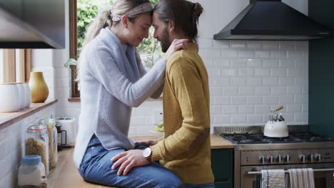 Caucasian-couple-shares-a-tender-moment-in-the-kitchen,-hugging