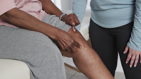 Caucasian-female-physiotherapist-checking-knee-of-senior-woman,-copy-space,-slow-motion
