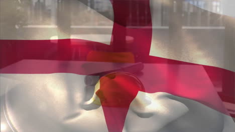 Animation-of-england-flag-waving-over-yellow-helmet-and-floor-plan-on-table-against-glass-window